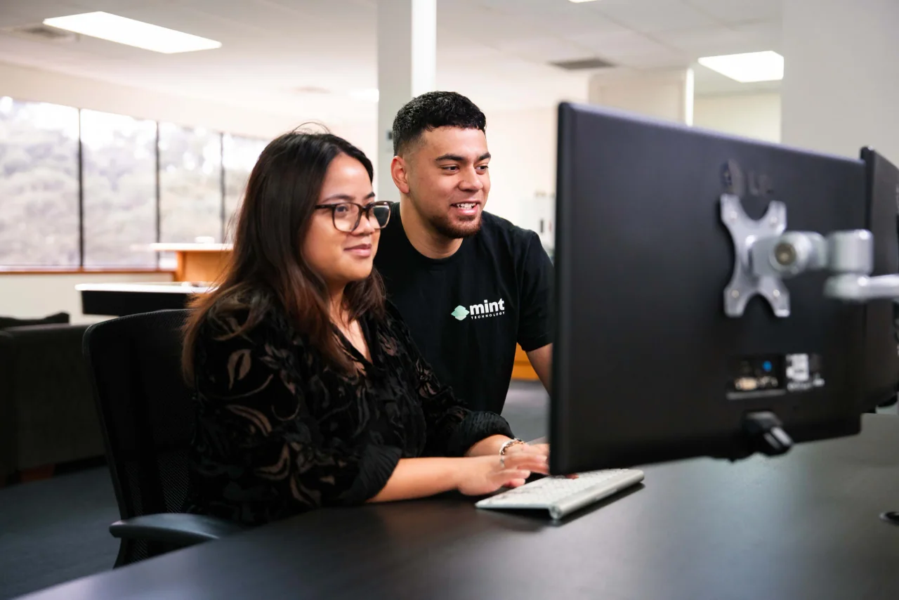 A Mint technician helping a colleague