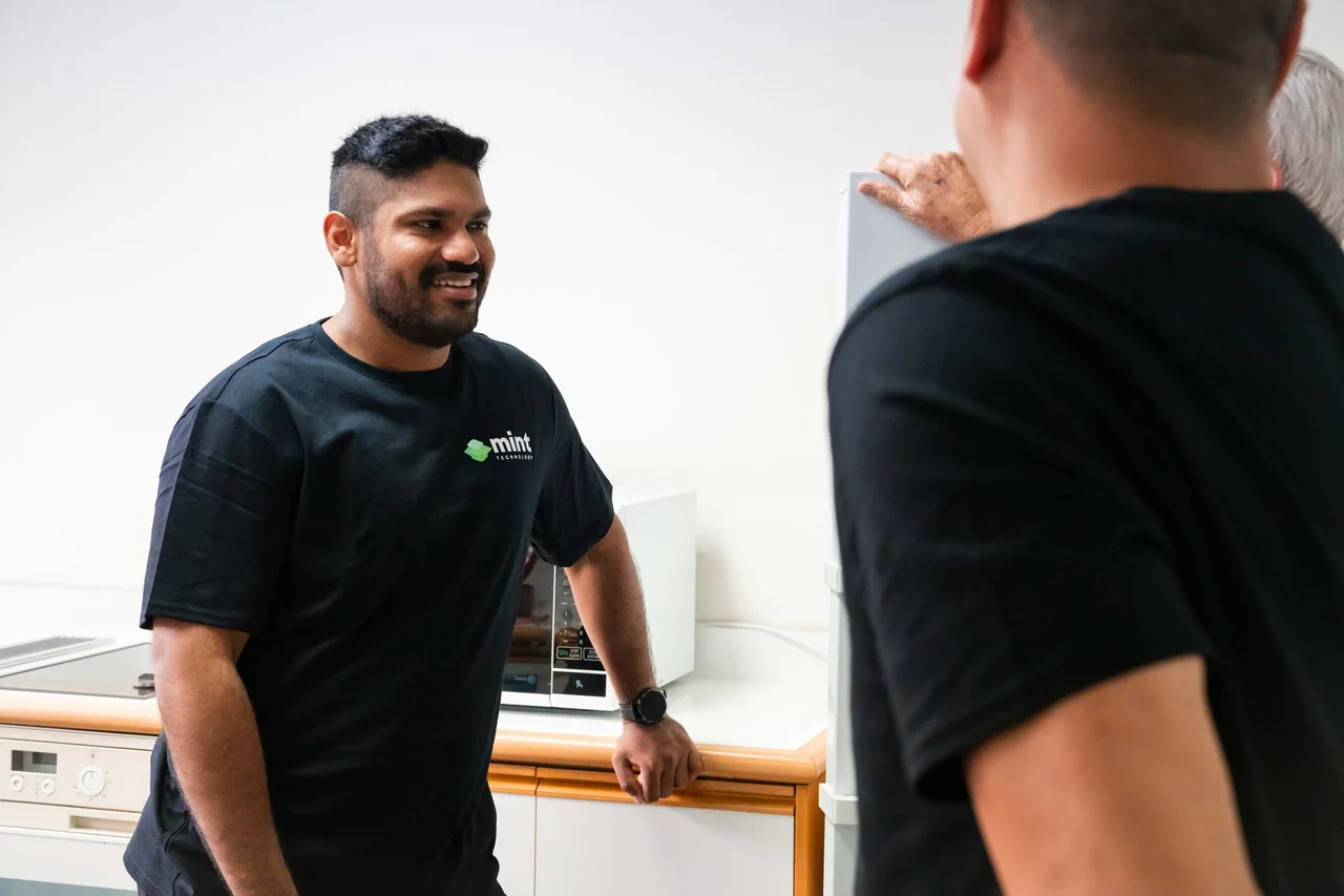 Two Mint team members chatting in the office kitchen