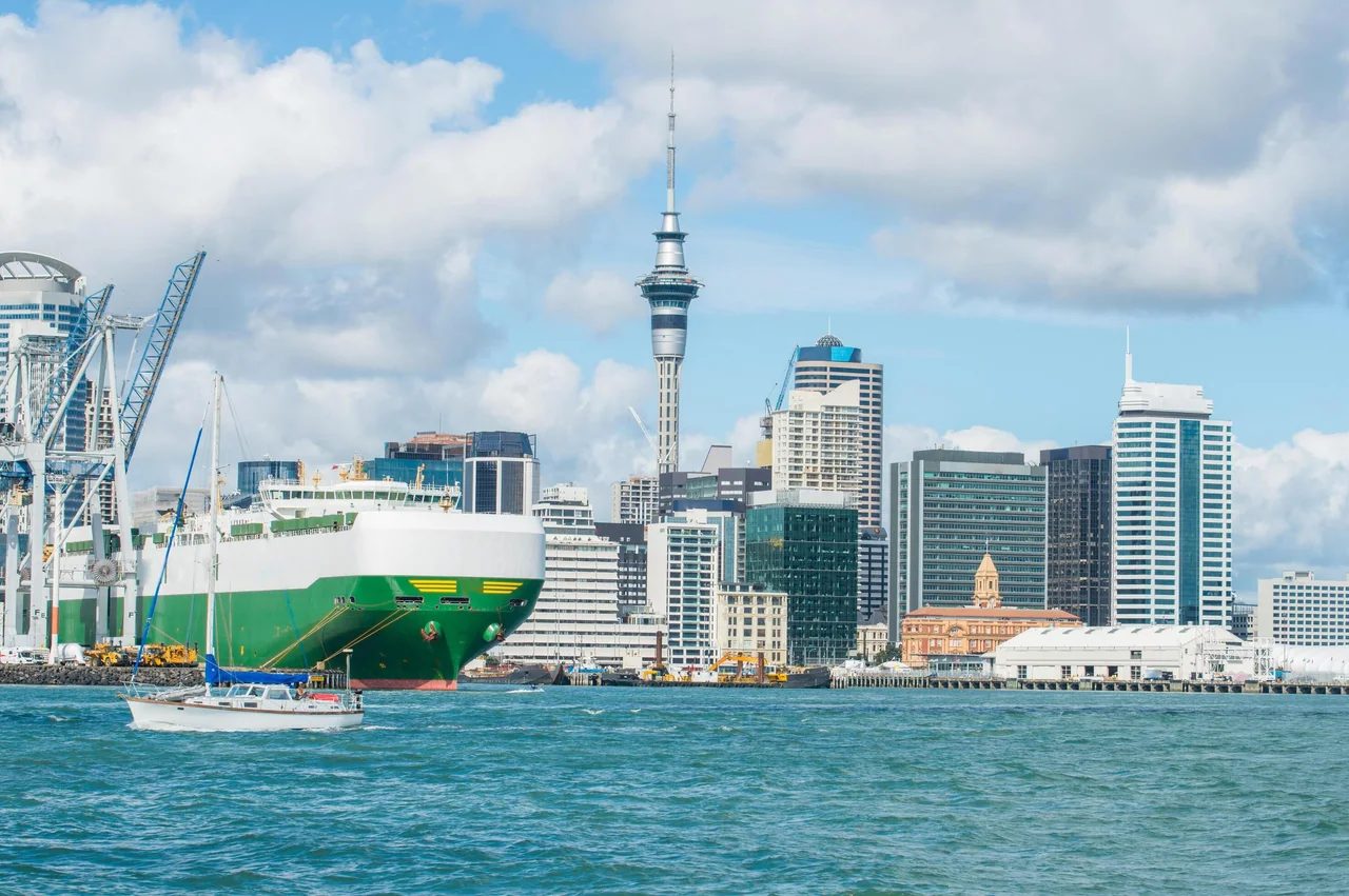 A car carrier ship in Auckland's harbour with the Sky Tower behind
