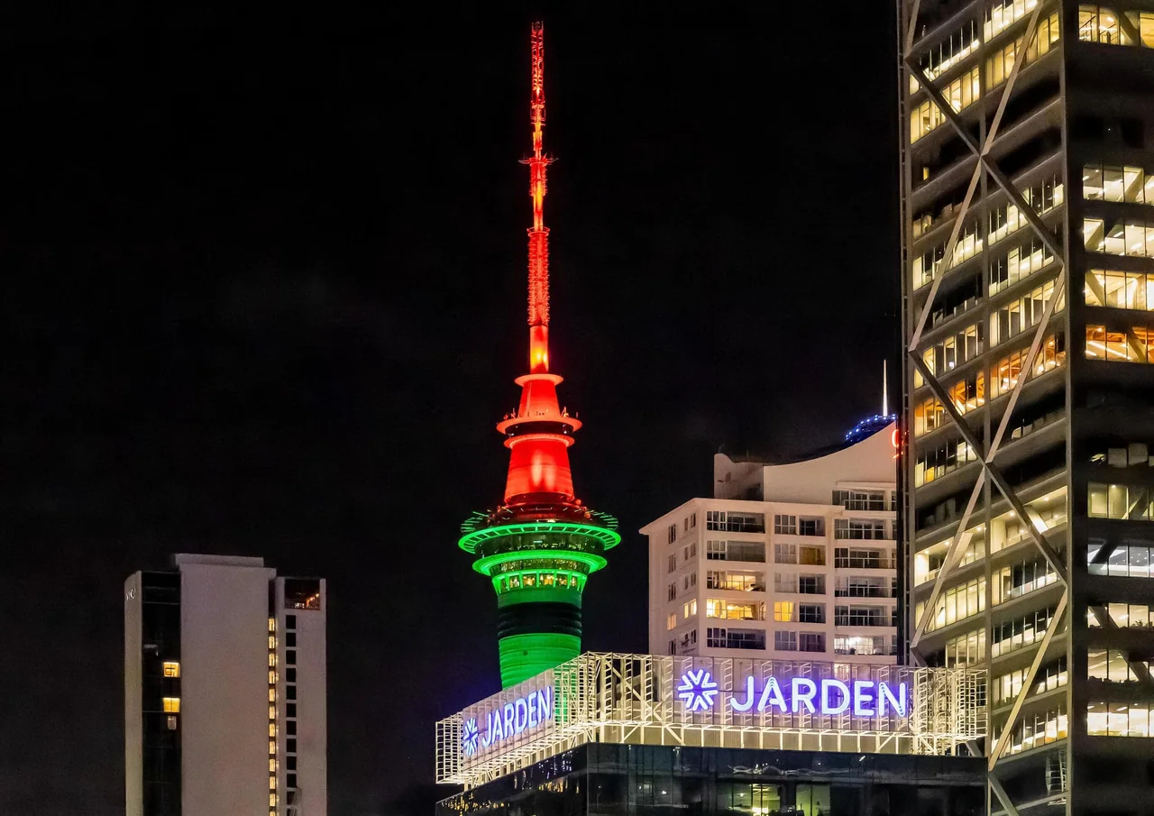 The Auckland Sky Tower lit up at night above the city
