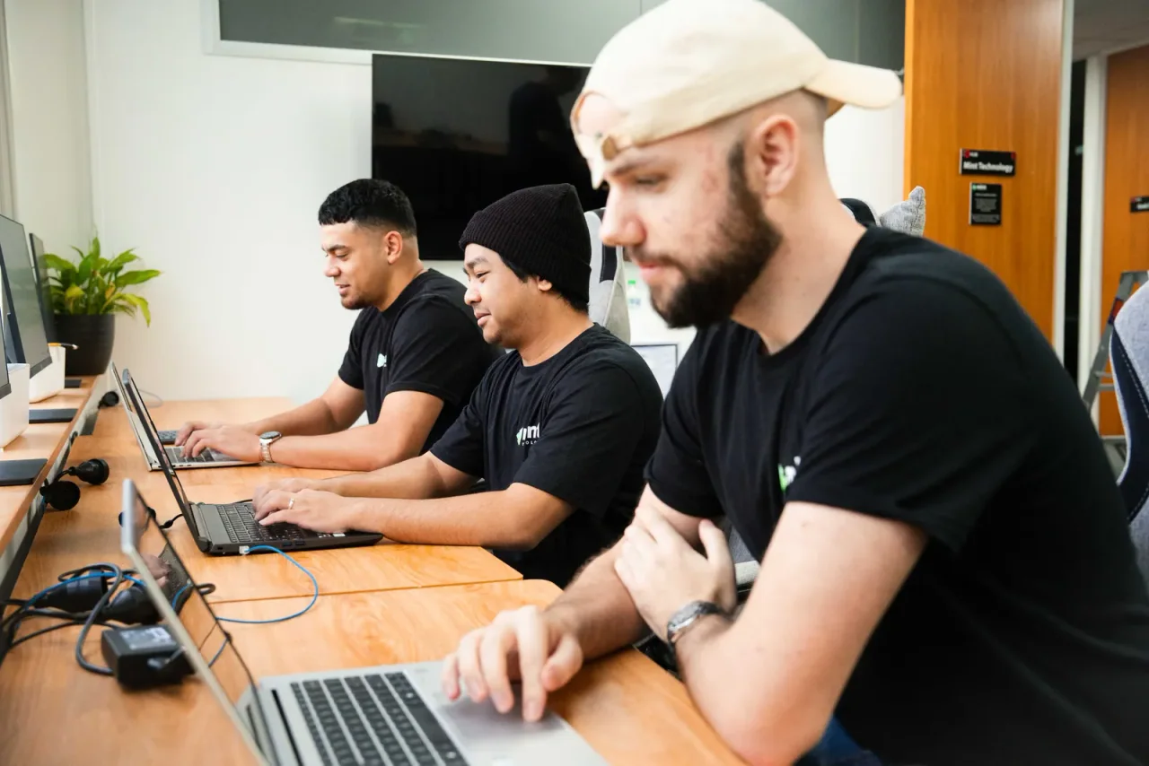 Three Mint technicians working on laptops at the Birkenhead office